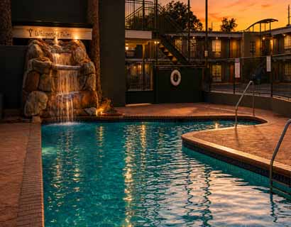 Outdoor swimming pool with waterfall at Whispering Palms Inn